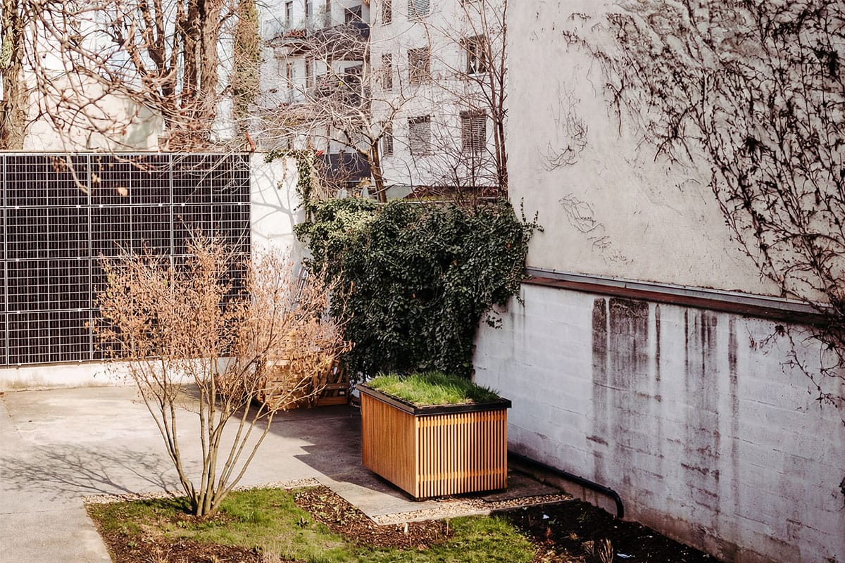 Absorberfläche und verkleidetes Modul im begrünten Innenhof eines Zinshauses